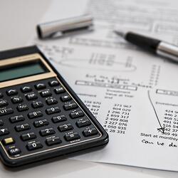 Image od calculator on white table with documents and pen