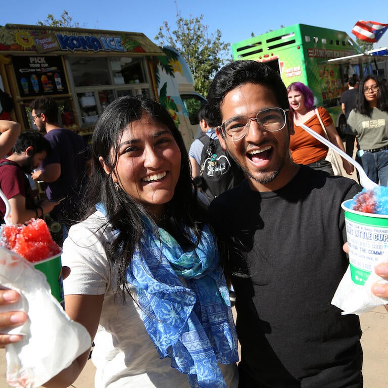 two students at an event holding shaved ice